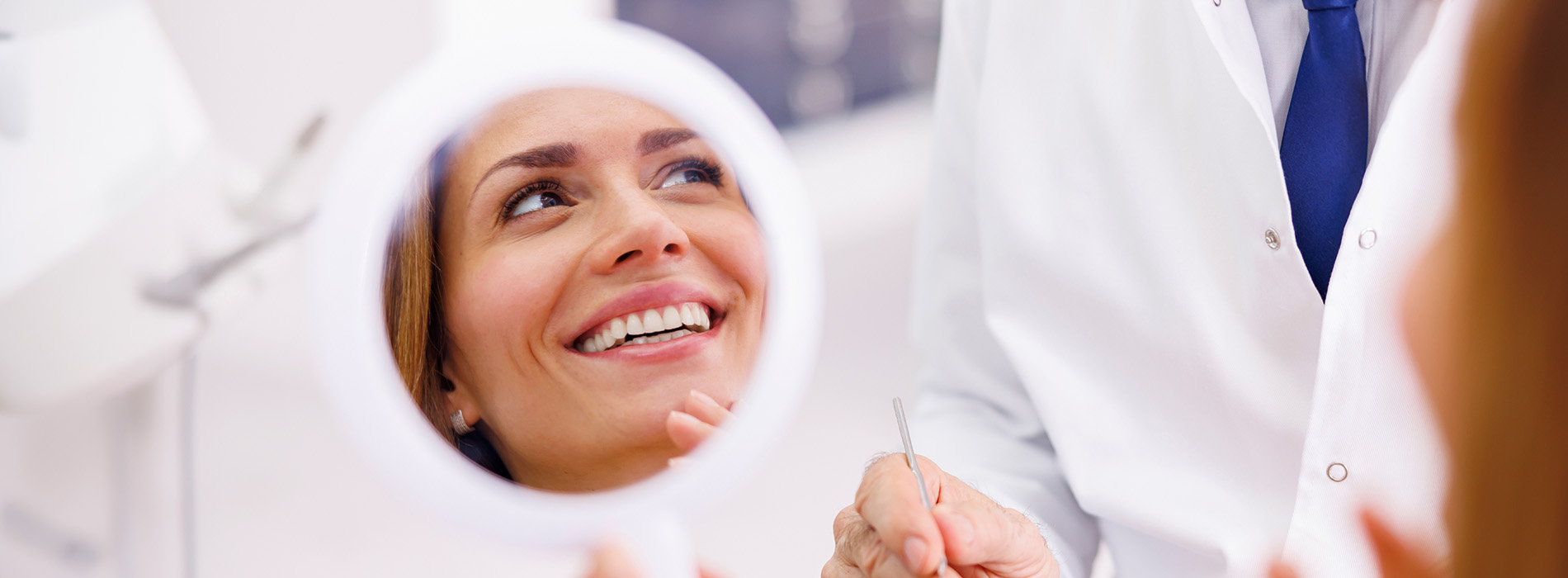 The image is a photograph of a woman with light skin, smiling at the camera. She appears to be in her late twenties or early thirties and has long hair. Her eyes are looking directly at the camera, and she is holding up her index finger near her mouth as if she s making a point or emphasizing something. The background is plain and light-colored, which suggests that this could be a stock photo used for various purposes such as advertising, personal branding, or lifestyle content.