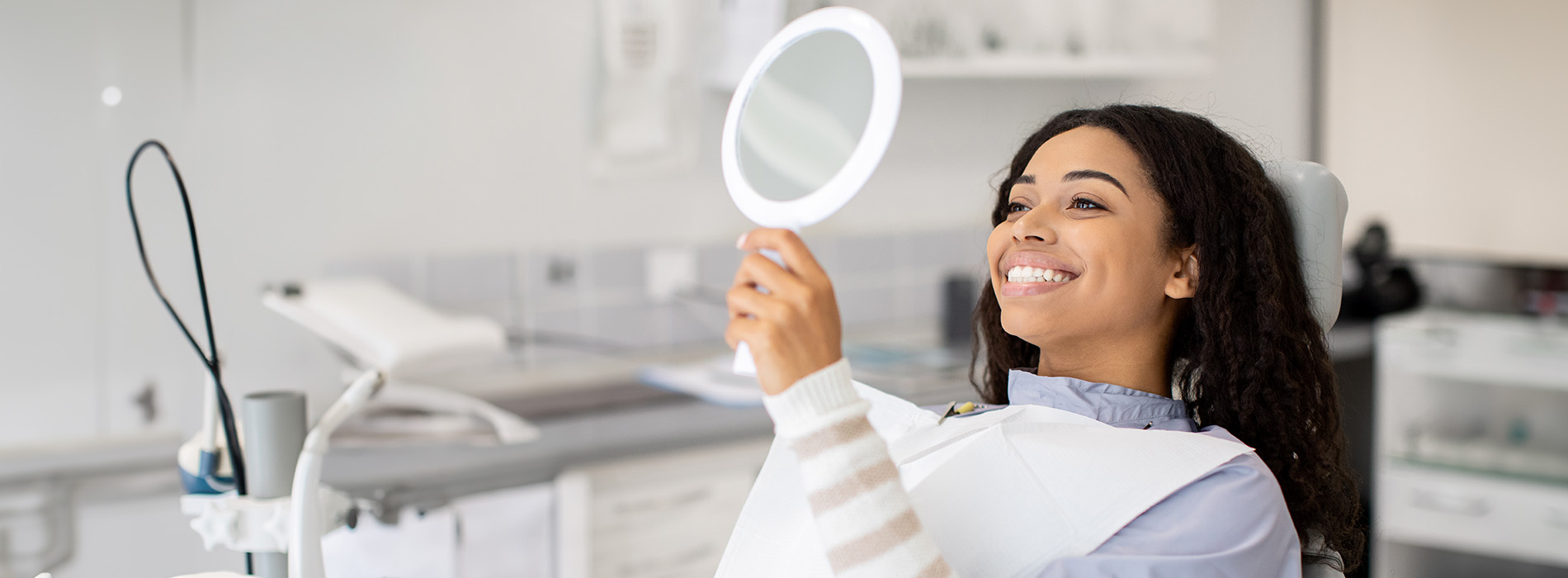 A well-lit reception area with a desk, computer monitor, and potted plant.