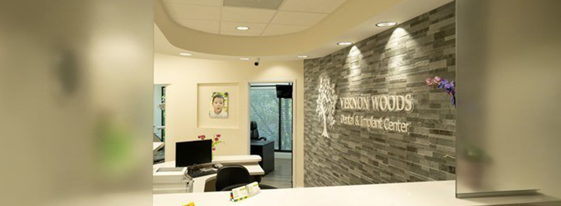 The image shows a modern dental clinic interior with various pieces of equipment, including a dental chair and an X-ray machine.